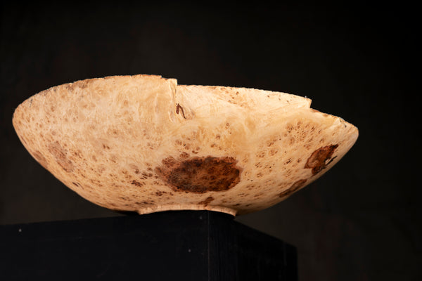 The maple burl bowl Evie held in hands to show its size and natural edge detail.
